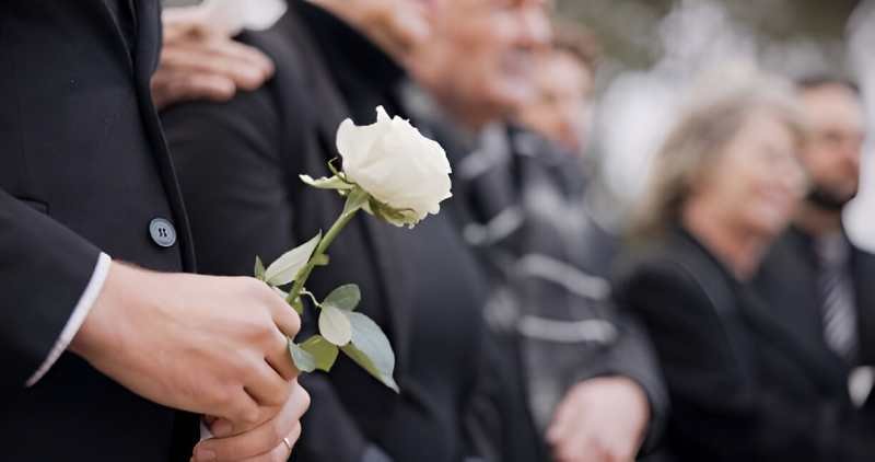 persone holding rose in funeral